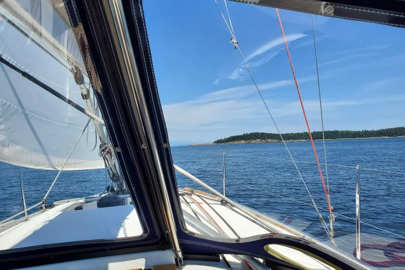 Imagine Yacht Photos Pics Sailing view from Jeanneau Sun Odyssey 349, 2017, on a clear day near an island.