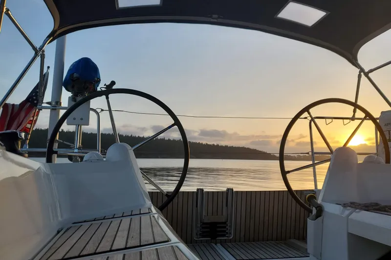 Imagine Yacht Photos Pics 2017 Jeanneau Sun Odyssey 349 sailboat cockpit at sunset on calm waters.