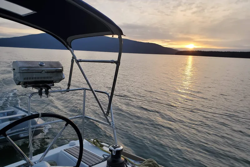 Imagine Yacht Photos Pics Jeanneau Sun Odyssey 349 sailing at sunset, 2017 model, serene lake view.