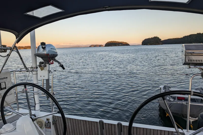 Imagine Yacht Photos Pics Cockpit view from 2017 Jeanneau Sun Odyssey 349 sailboat, overlooking serene waters and distant islands.