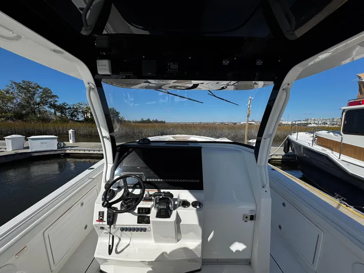 Bali Hai Yacht Photos Pics 2020 Edgewater 370CC boat helm with steering wheel and controls, docked in a marina.