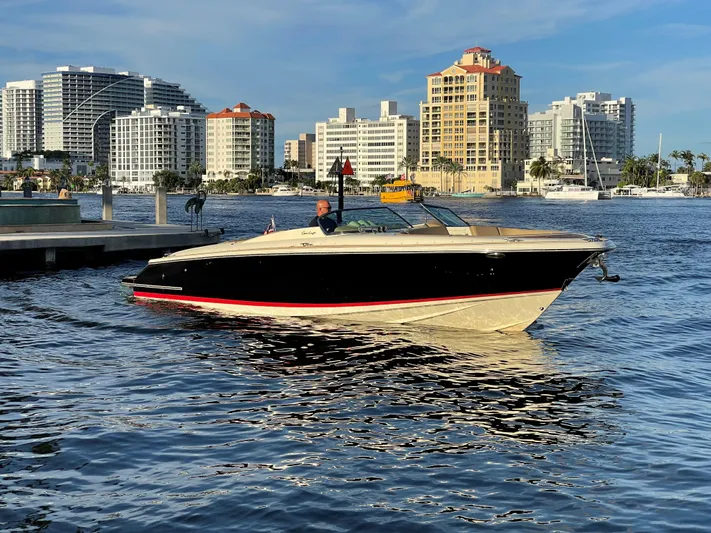 Grato Yacht Photos Pics 2015 Chris-Craft 32 Launch boat cruising near urban waterfront skyline.