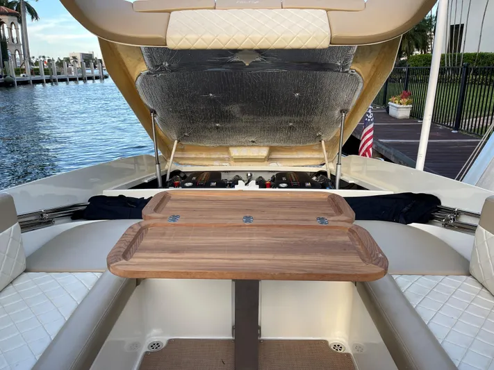 Grato Yacht Photos Pics 2015 Chris-Craft 32 Launch boat interior with open engine hatch and wooden table.
