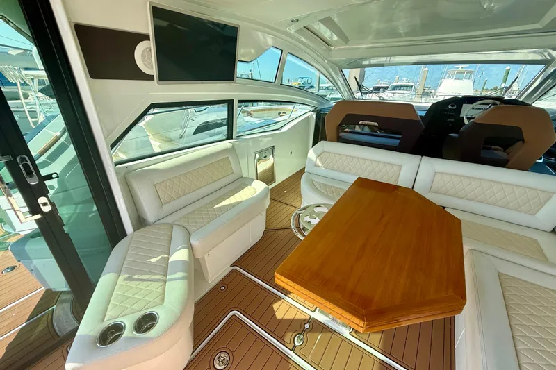 New Trade-in- All Offers & Trades Welcome Yacht Photos Pics Luxurious interior of 2019 Beneteau Gran Turismo 46 yacht with elegant seating and wooden table.
