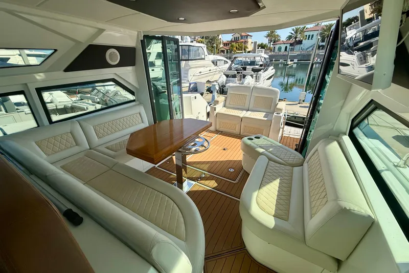New Trade-in- All Offers & Trades Welcome Yacht Photos Pics Luxurious interior of 2019 Beneteau Gran Turismo 46 yacht with elegant seating and wooden table.