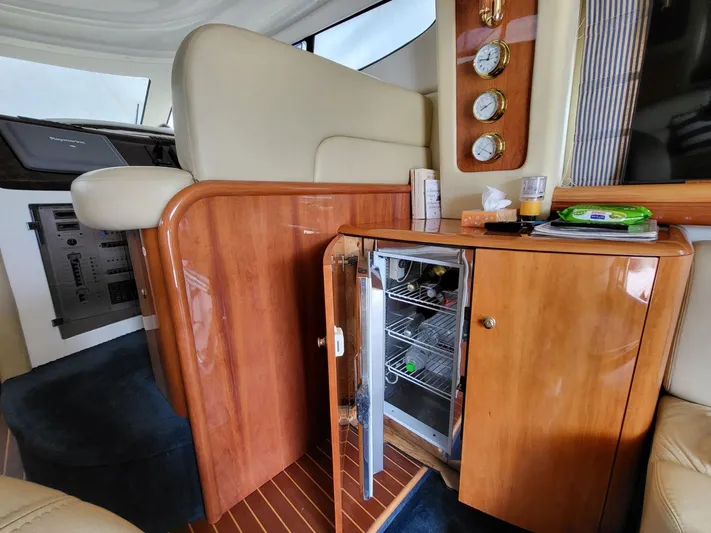  Yacht Photos Pics Interior of 2006 Cranchi 48 Fly yacht with open mini fridge and wooden cabinetry.