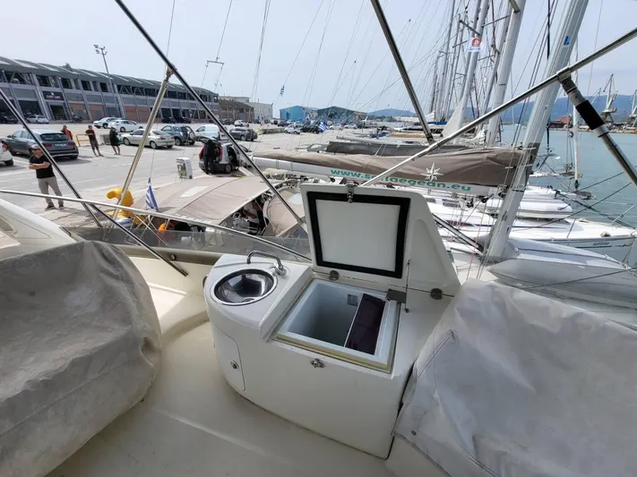  Yacht Photos Pics 2006 Cranchi 48 Fly yacht deck with open storage and sink, docked at marina.