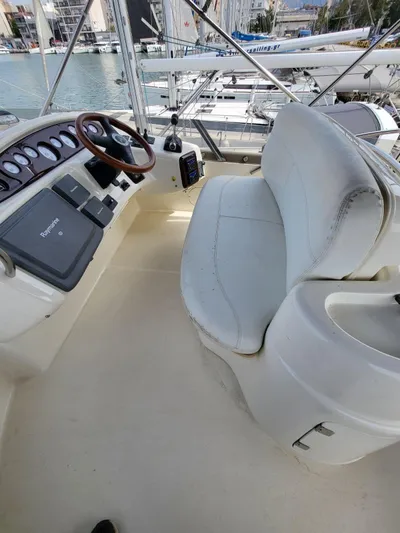  Yacht Photos Pics 2006 Cranchi 48 Fly yacht cockpit with steering wheel and seating, docked at marina.