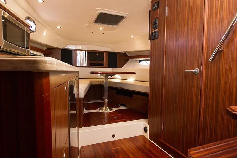 Lady Ann Name Reserved Yacht Photos Pics 2018 Pursuit OS 355 Offshore cabin interior with wood finish and seating area.