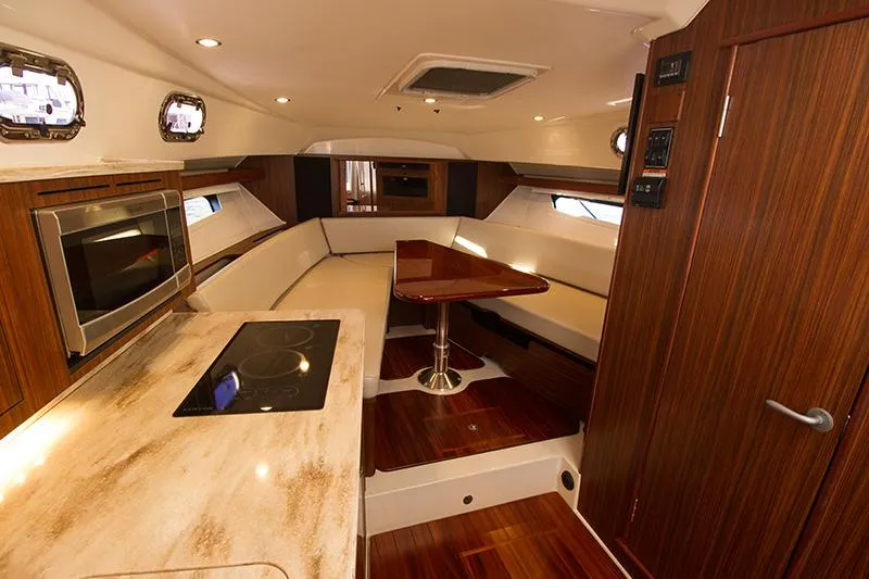 Lady Ann Name Reserved Yacht Photos Pics Luxurious interior of 2018 Pursuit OS 355 Offshore yacht with modern kitchen and seating area.