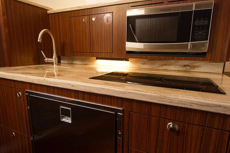 Lady Ann Name Reserved Yacht Photos Pics 2018 Pursuit OS 355 Offshore yacht kitchen with wood cabinetry and modern appliances.