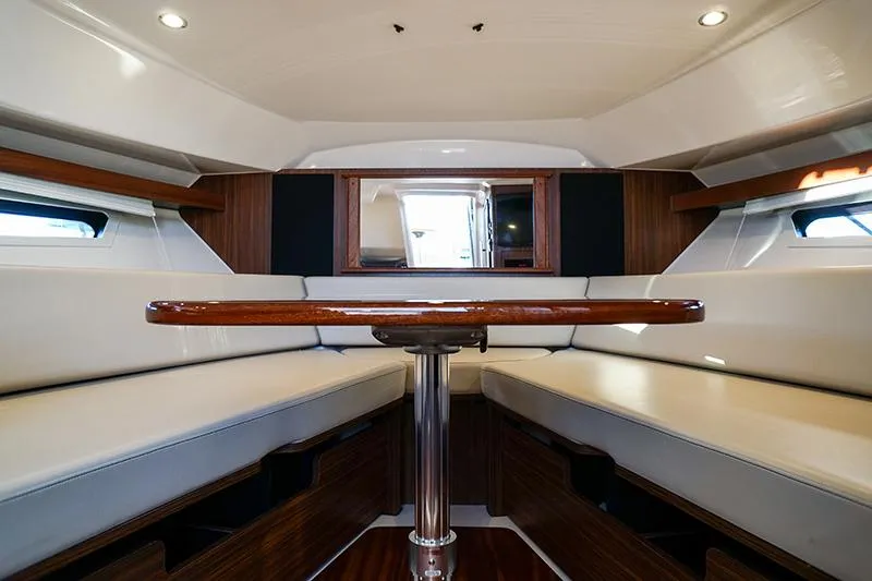 Lady Ann Name Reserved Yacht Photos Pics 2018 Pursuit OS 355 Offshore cabin interior with seating and wooden table.