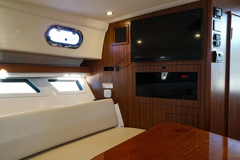Lady Ann Name Reserved Yacht Photos Pics 2018 Pursuit OS 355 Offshore cabin interior with TV and seating area.