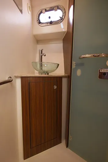 Lady Ann Name Reserved Yacht Photos Pics 2018 Pursuit OS 355 Offshore bathroom with glass sink and wooden cabinet.