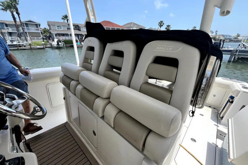  Yacht Photos Pics 2019 Boston Whaler 330 Outrage boat seats, docked near waterfront homes.