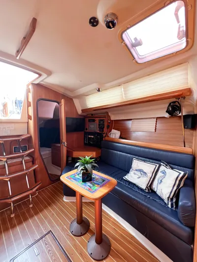 Cheers Yacht Photos Pics Interior of a 2006 Catalina 350 sailboat with cozy seating and wooden accents.