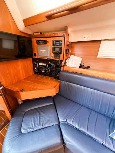 Cheers Yacht Photos Pics 2006 Catalina 350 yacht interior with navigation panel and blue seating.
