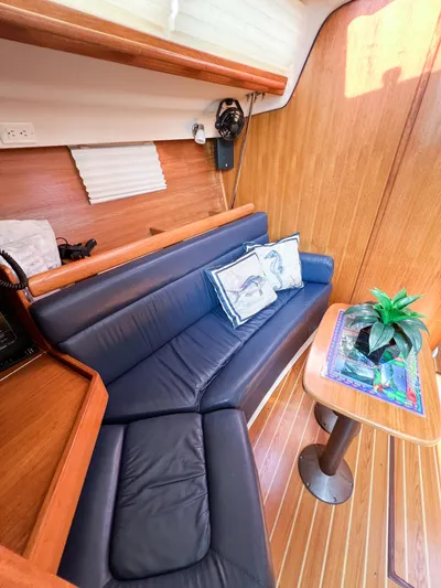 Cheers Yacht Photos Pics Interior of 2006 Catalina 350 sailboat with blue seating and wooden table.