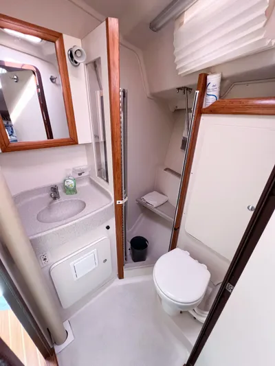 Cheers Yacht Photos Pics 2006 Catalina 350 yacht bathroom with sink, mirror, and toilet.