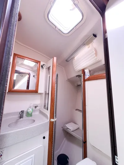 Cheers Yacht Photos Pics 2006 Catalina 350 yacht bathroom with sink, mirror, and storage shelves.