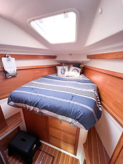 Cheers Yacht Photos Pics 2006 Catalina 350 yacht cabin with cozy bed, wooden interior, and overhead skylight.