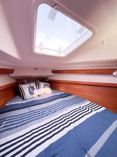 Cheers Yacht Photos Pics Interior cabin of 2006 Catalina 350 sailboat with skylight and striped bedding.