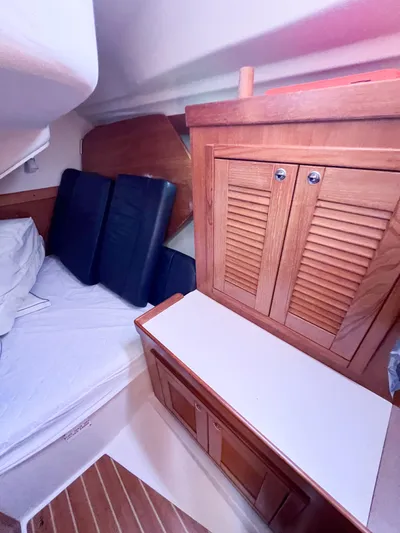 Cheers Yacht Photos Pics Interior cabin of a 2006 Catalina 350 sailboat with wooden cabinetry and bedding.
