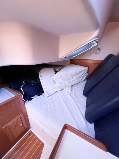 Cheers Yacht Photos Pics Interior cabin of a 2006 Catalina 350 sailboat with bed and wooden accents.