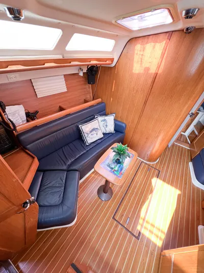 Cheers Yacht Photos Pics Interior of 2006 Catalina 350 sailboat with wooden flooring and blue seating.