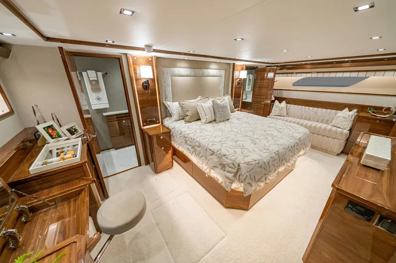 2026 Viking 90sb Yacht Photos Pics Luxurious bedroom interior of 2026 Viking 90 Sky Bridge yacht, featuring elegant wood finishes.