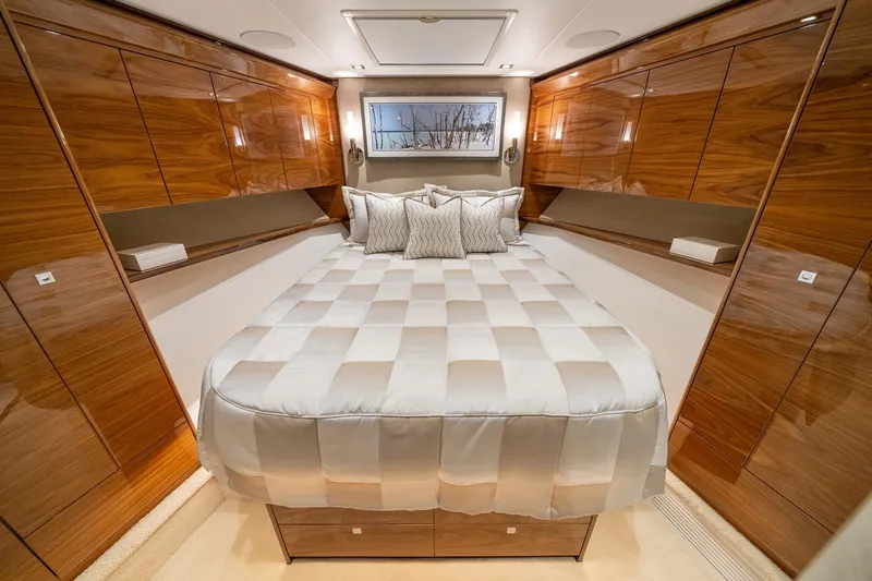2026 Viking 90sb Yacht Photos Pics Luxurious bedroom interior of 2026 Viking 90 Sky Bridge yacht with elegant wood paneling.