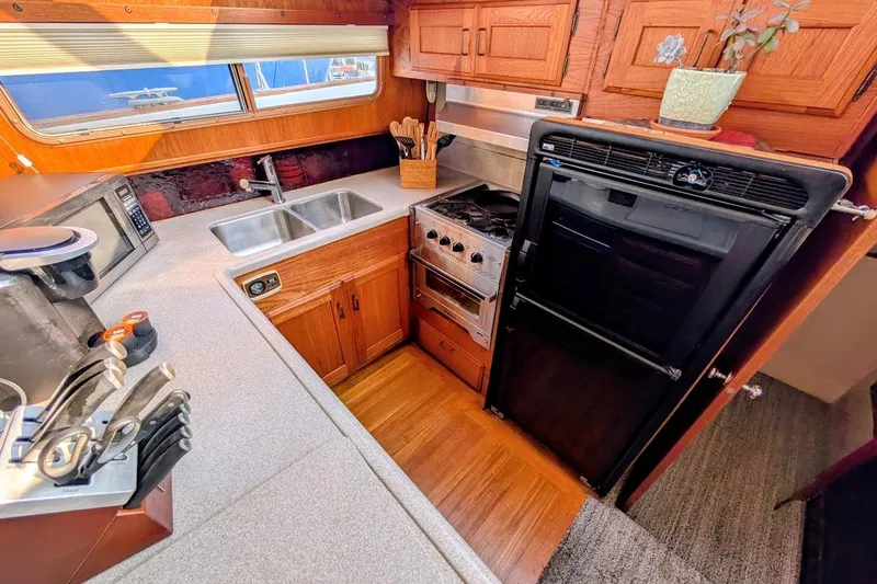 Innovation Yacht Photos Pics 1978 Tollycraft 54 Custom Cockpit Motor Yacht kitchen with wood cabinetry and modern appliances.