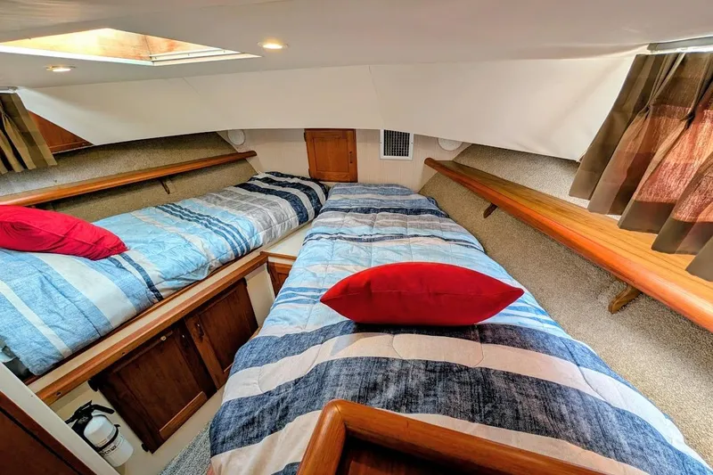 Innovation Yacht Photos Pics Interior of 1978 Tollycraft 54 Custom Cockpit Motor Yacht with twin beds and red pillows.