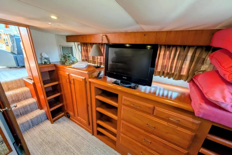 Innovation Yacht Photos Pics 1978 Tollycraft 54 Custom Cockpit Motor Yacht interior with TV, wooden cabinetry, and stairs.