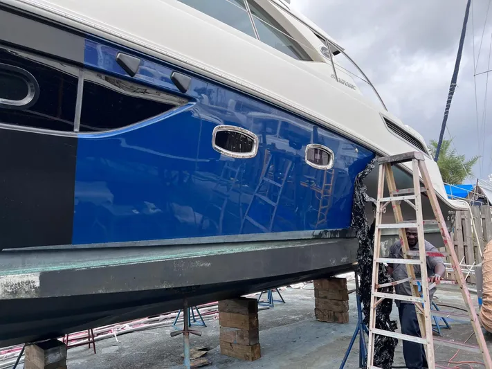 Moonwake Yacht Photos Pics 2014 Sea Ray 470 Sundancer yacht on blocks, undergoing maintenance with a ladder beside it.