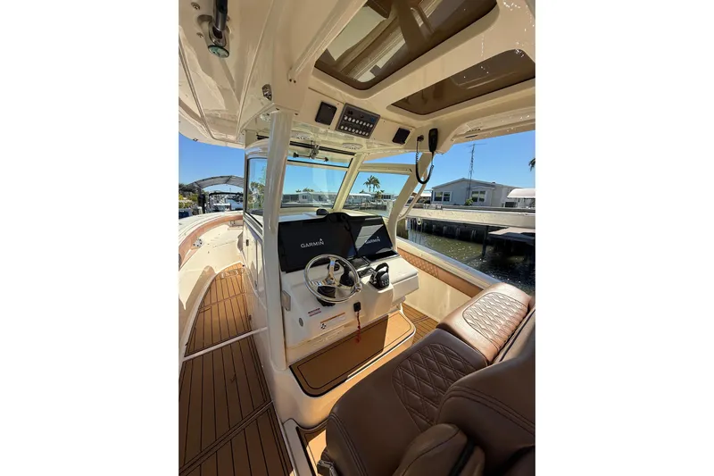 New Trade-in- All Offers & Trades Welcome Yacht Photos Pics 2018 Scout 350 LXF boat interior with Garmin navigation, luxurious seating, and wood flooring.