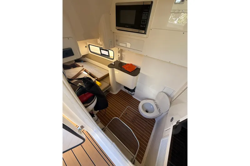 New Trade-in- All Offers & Trades Welcome Yacht Photos Pics 2018 Scout 350 LXF cabin interior with wood flooring, toilet, and microwave.