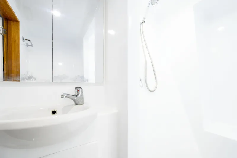 One Off Yacht Photos Pics Modern bathroom interior on 2019 Coral Coast 62 Power Catamaran, featuring sleek sink and shower.