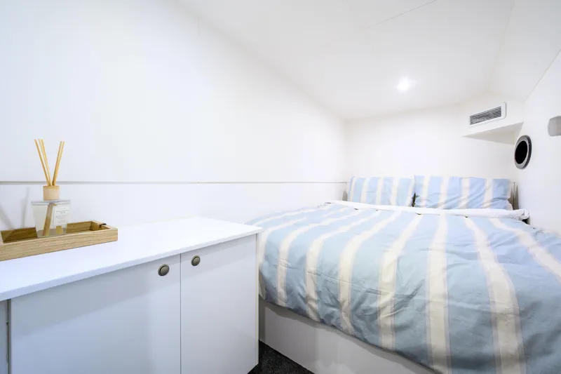 One Off Yacht Photos Pics Cozy bedroom in 2019 Coral Coast 62 Power Catamaran with striped bedding and modern decor.