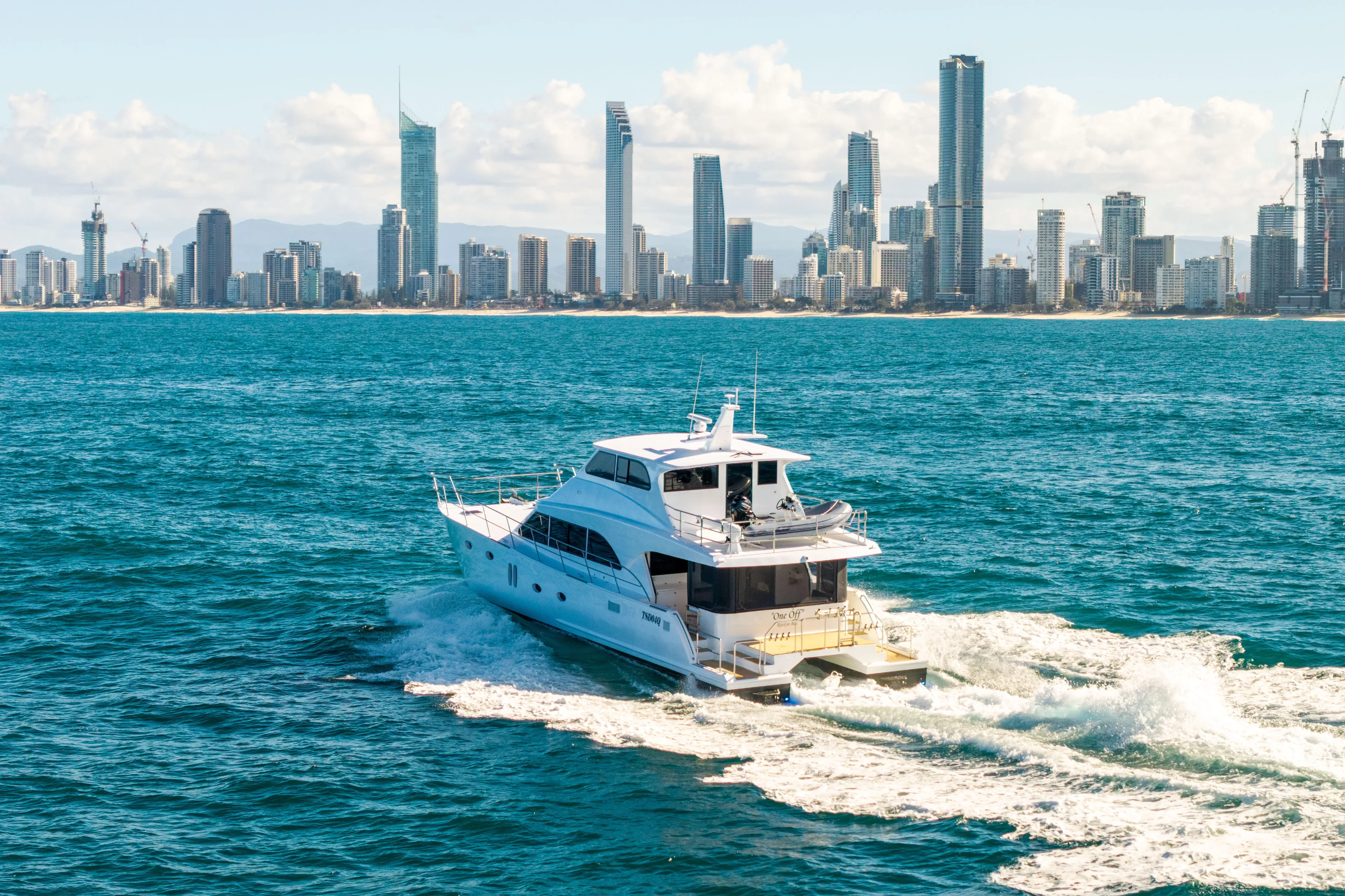 One Off Yacht Photos Pics Luxurious 2019 Coral Coast 62 Power Catamaran cruising near city skyline.