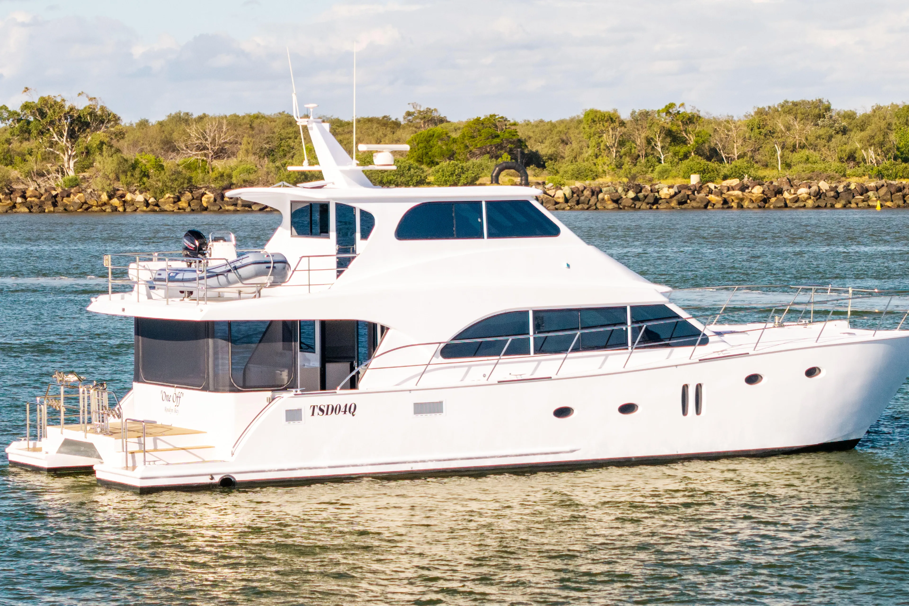 One Off Yacht Photos Pics 2019 Coral Coast 62 Power Catamaran cruising on a serene waterway.