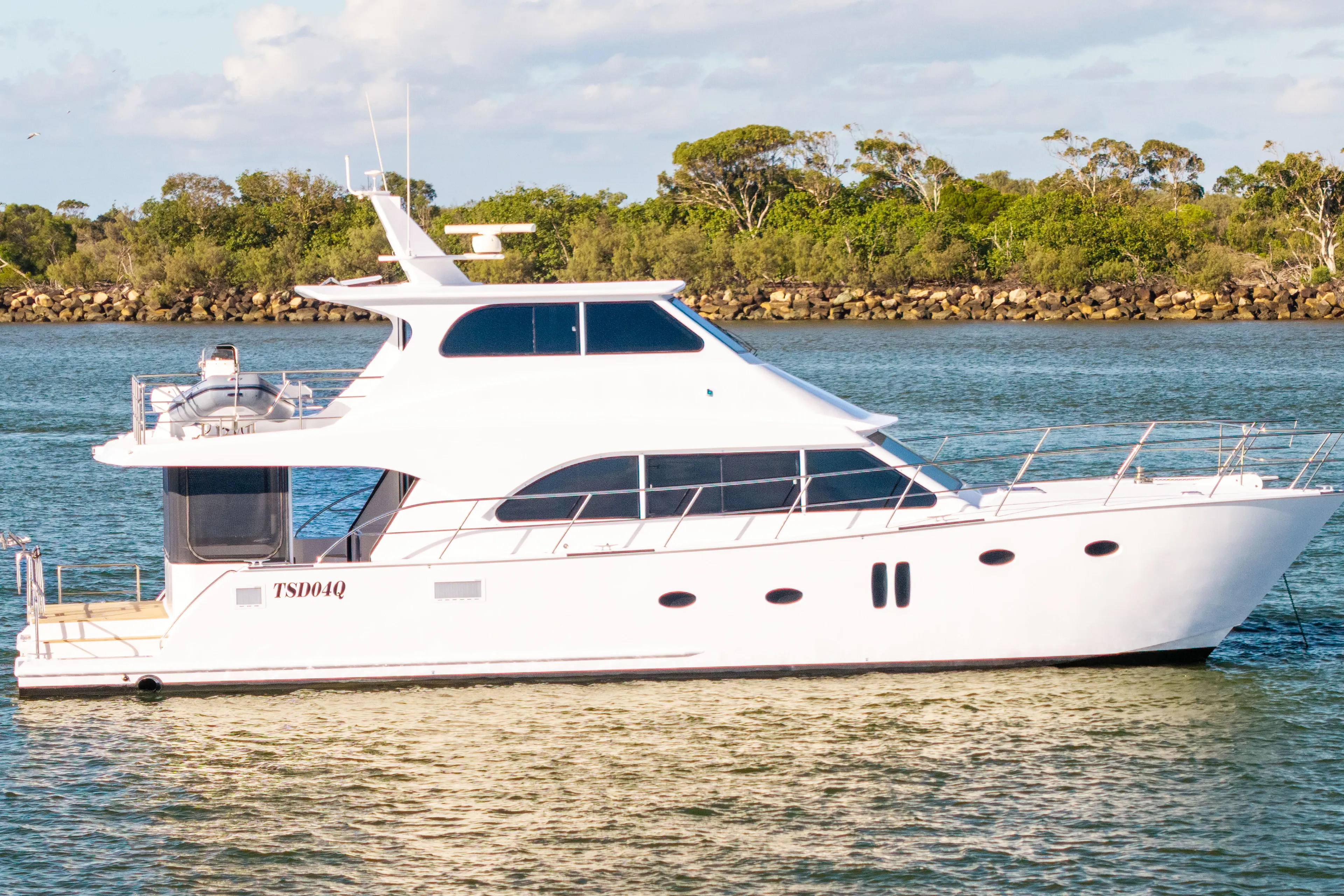 One Off Yacht Photos Pics 2019 Coral Coast 62 Power Catamaran cruising on a serene waterway.