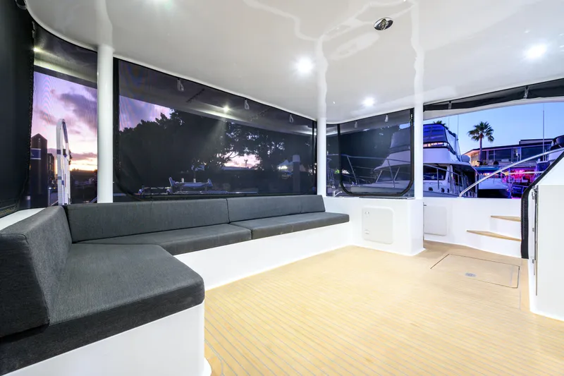 One Off Yacht Photos Pics Luxurious interior of 2019 Coral Coast 62 Power Catamaran at sunset, featuring spacious seating.