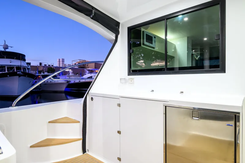 One Off Yacht Photos Pics Interior view of 2019 Coral Coast 62 Power Catamaran with modern design and marina backdrop.