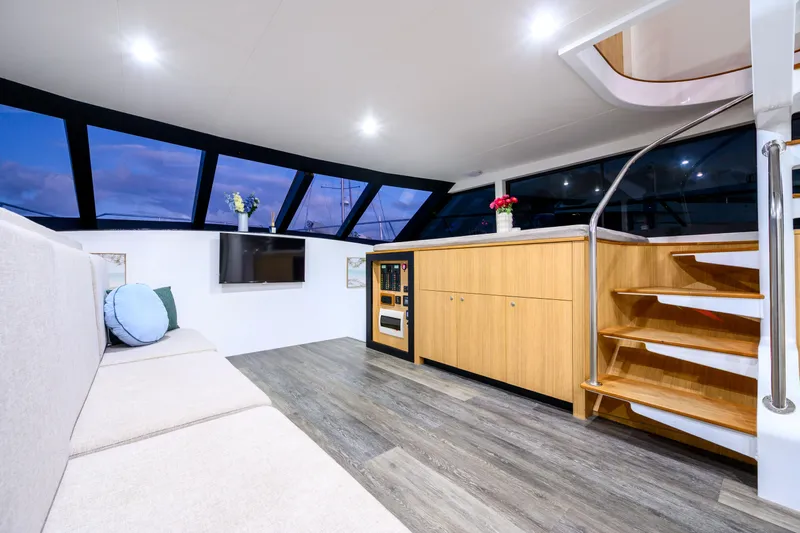 One Off Yacht Photos Pics Luxurious interior of 2019 Coral Coast 62 Power Catamaran with modern furnishings and panoramic windows.