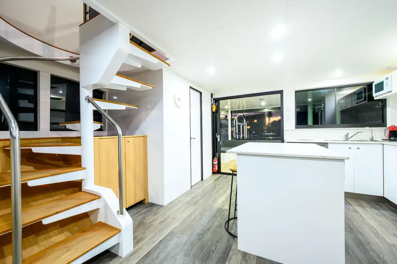 One Off Yacht Photos Pics Modern interior of 2019 Coral Coast 62 Power Catamaran with sleek kitchen and wooden staircase.