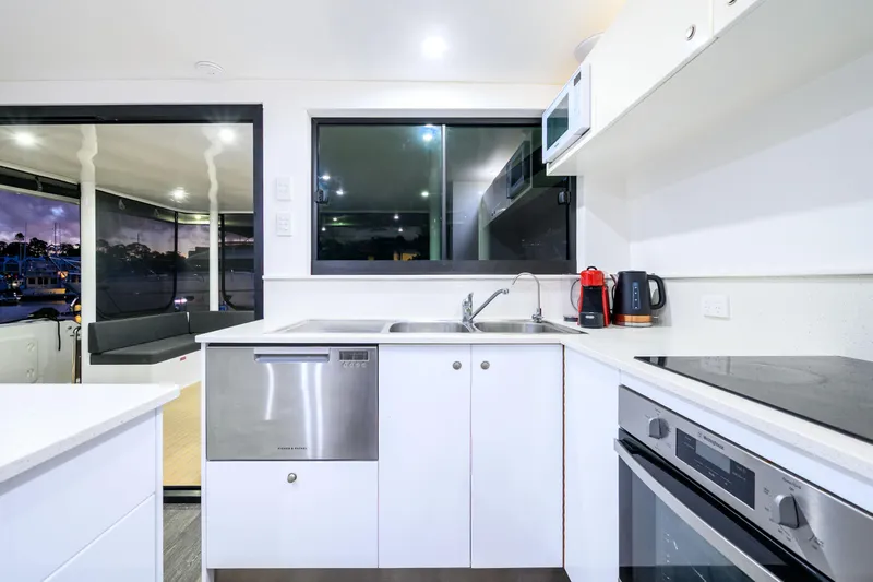 One Off Yacht Photos Pics Modern kitchen interior on 2019 Coral Coast 62 Power Catamaran, featuring sleek appliances and spacious design.