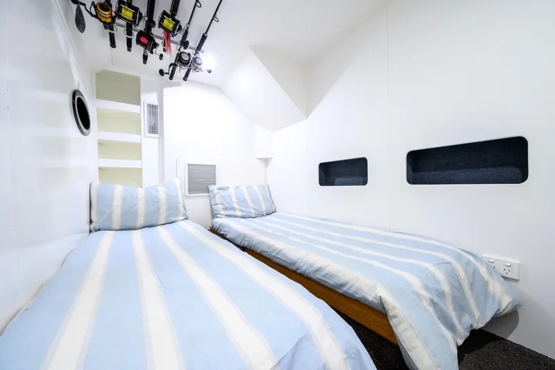 One Off Yacht Photos Pics Interior of 2019 Coral Coast 62 Power Catamaran with twin beds and fishing rods.