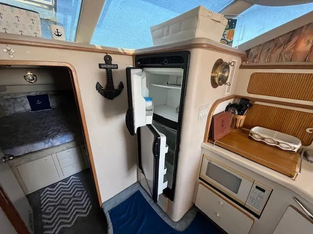 Papa's 7 II Yacht Photos Pics Interior of 1995 Sea Ray 440 Express Bridge with kitchenette and open fridge.