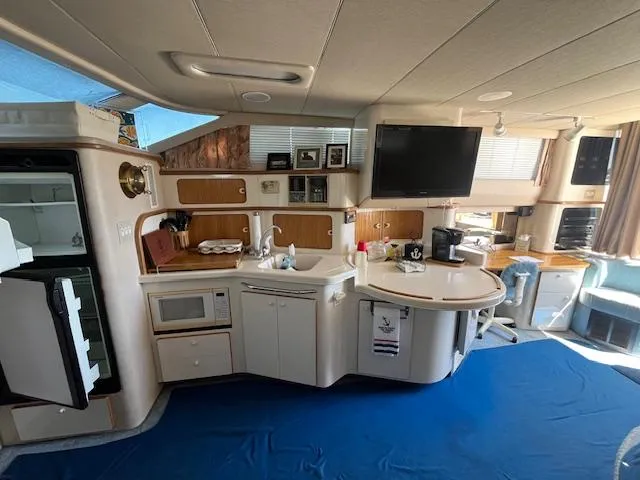Papa's 7 II Yacht Photos Pics Interior of 1995 Sea Ray 440 Express Bridge yacht with kitchen and seating area.